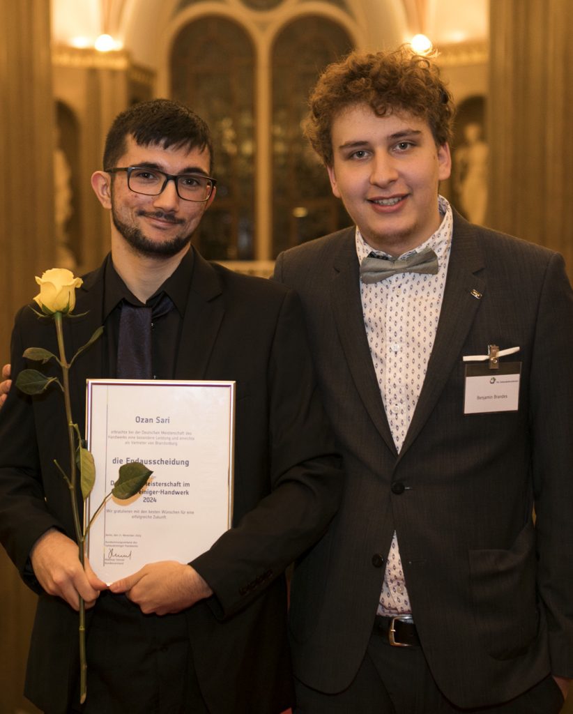 Unser Ozan Sari hält seine Teilnehmer Urkunde